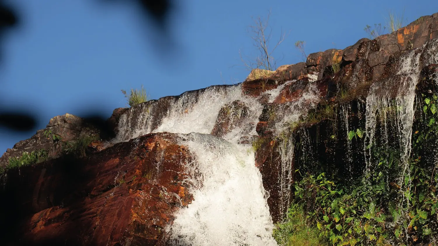 Cachoeira sobre a rocha avermelhada